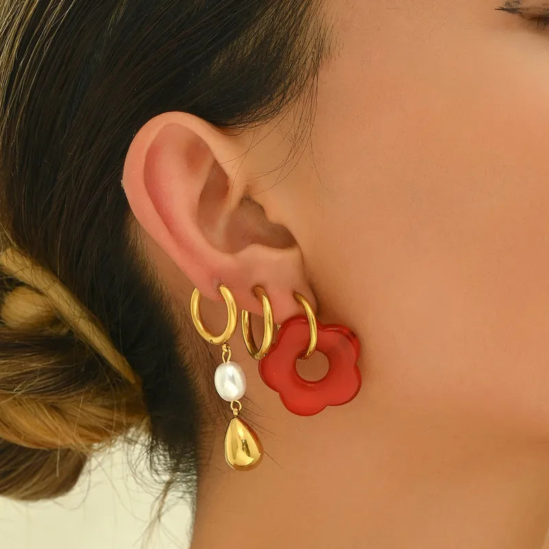 Boucles d’oreilles avec pendentif, portées sur une oreille de femme