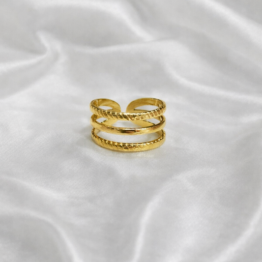 Bague Camélia en acier inoxydable doré à trois anneaux fins, portée à la main – La Merveille Bijoux