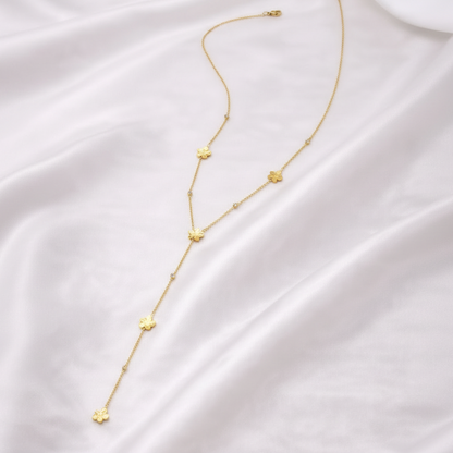 Collier Y Élina avec fleurs dorées en acier inoxydable porté sur décolleté 